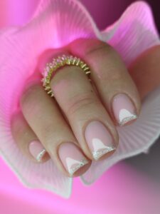 Manicure w kolorze różowym z srebrnym brokatem na ko\ncówkach