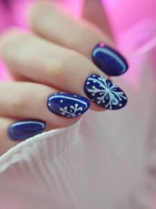 Paznokcie pomalowane na niebiesko i biała wzorki